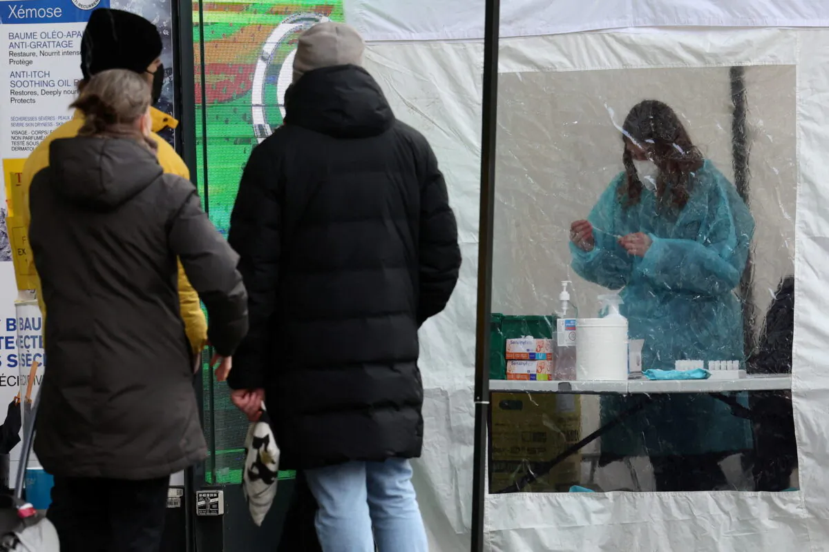 A medical worker prepares to administer a nasal swab to a patient at a testing booth outside a pharmacy in Paris, on Jan.7, 2022. (Sarah Meyssonnier/Reuters)