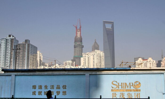 A wall carrying the logo of Shimao Group, with residential buildings and the financial district of Pudong in the background on January 1, 2013, in Shanghai, China. (Stringer/Reuters)