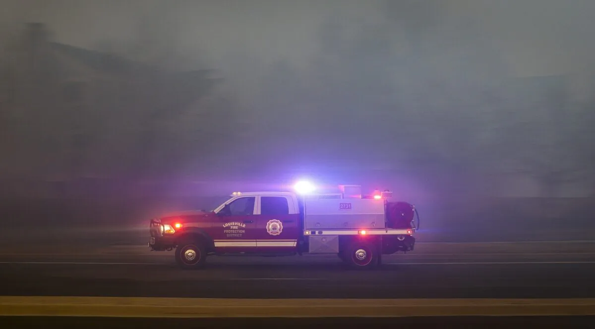 A Fire Protection District vehicle races to another hotspot in the Centennial Heights neighborhood, as a fast moving wildfire swept through the area in Louisville, Colo., on Dec. 30, 2021. (Marc Piscotty/Getty Images)