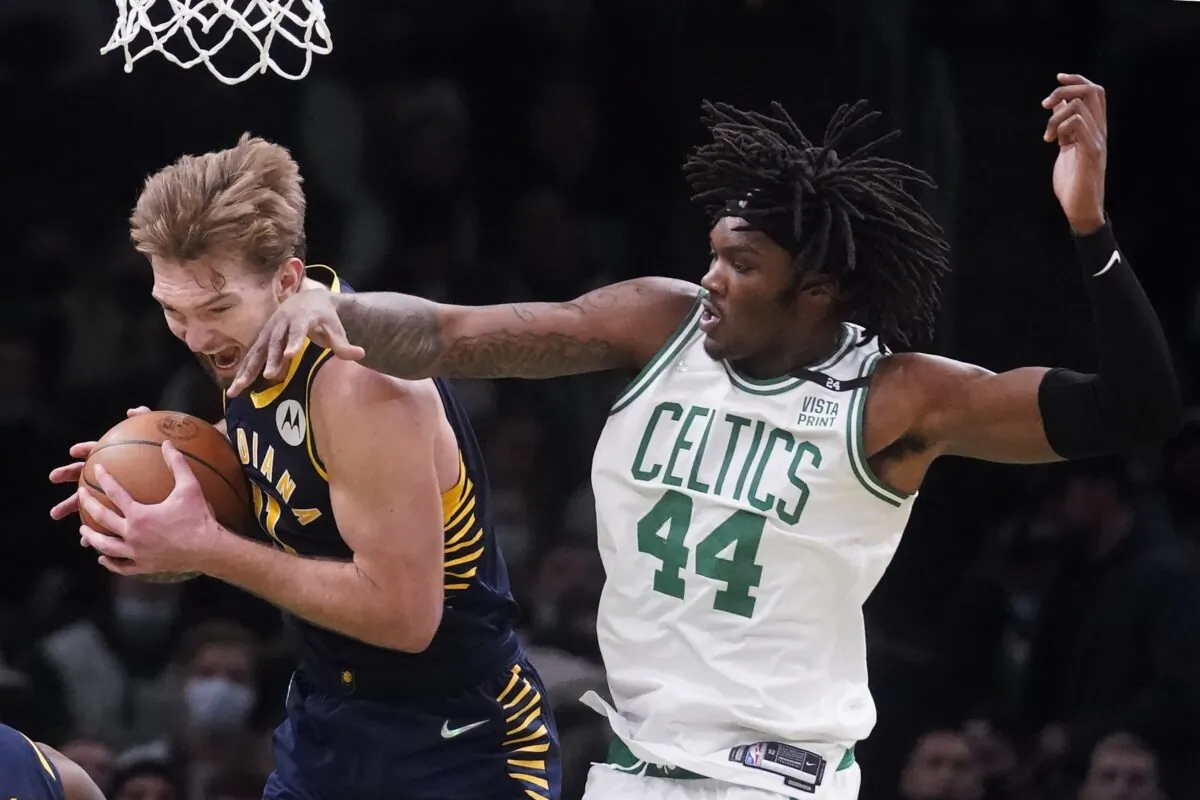 Indiana Pacers forward Domantas Sabonis, left, grabs a rebound against Boston Celtics center Robert Williams III (44), during an NBA basketball game in Boston on Jan. 10, 2022. (Charles Krupa/AP Photo)