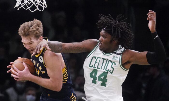 Indiana Pacers forward Domantas Sabonis, left, grabs a rebound against Boston Celtics center Robert Williams III (44), during an NBA basketball game in Boston on Jan. 10, 2022. (Charles Krupa/AP Photo)