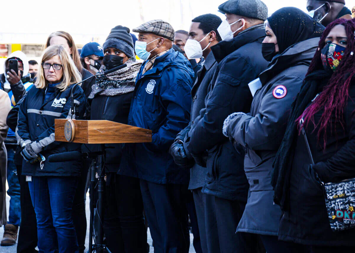 New York City Mayor Eric Adams, behind podium, gives a press conference at the site of the Jan. 9, 2022 five-alarm fire in the Bronx, New York on Jan. 10, 2022. Bronx borough president Vanessa Gibson looks on. (Dave Paone/The Epoch Times)