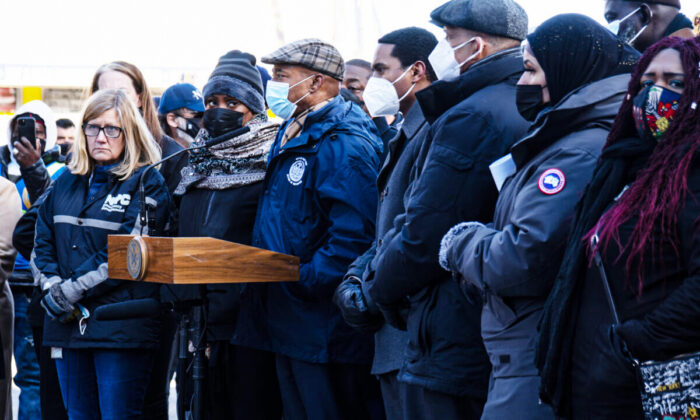 New York City Mayor Eric Adams, behind podium, gives a press conference at the site of the Jan. 9, 2022 five-alarm fire in the Bronx, New York on Jan. 10, 2022. Bronx borough president Vanessa  Gibson looks on. (Dave Paone/The Epoch Times)