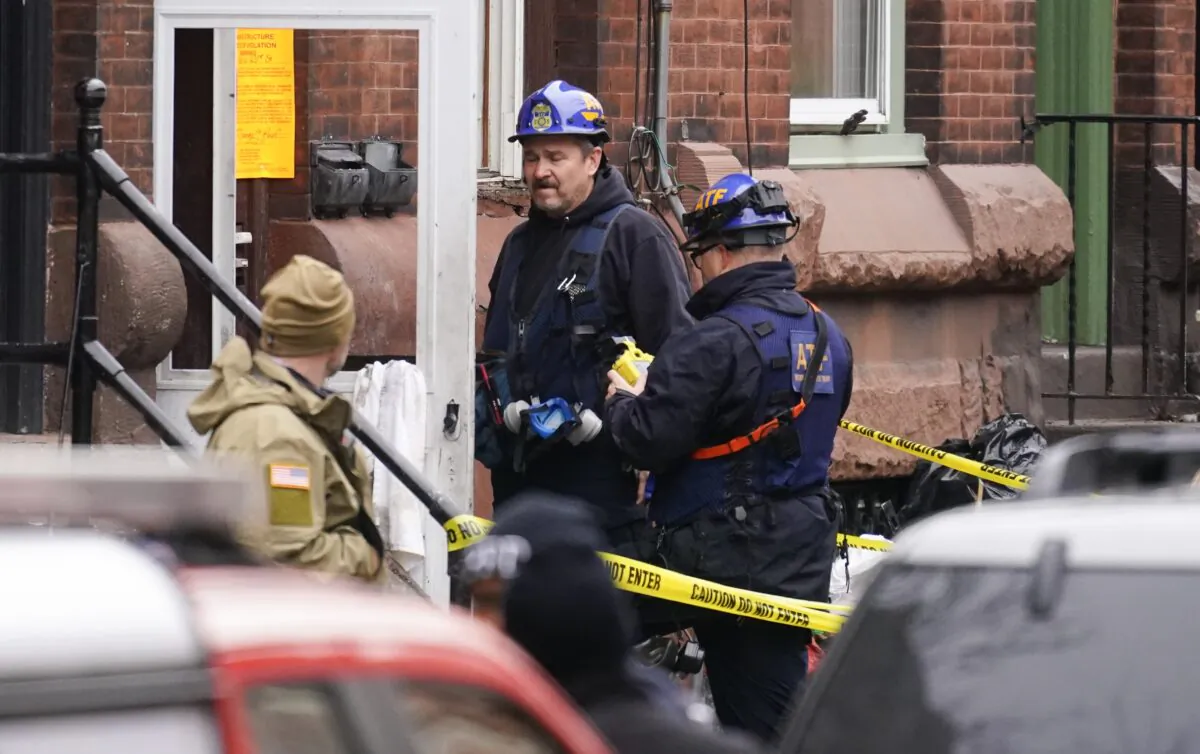 Investigators gather near the entrance to the building of Wednesday's fatal fire in the Fairmount neighborhood of Philadelphia, on Jan. 6, 2022. (Matt Rourke/AP Photo)