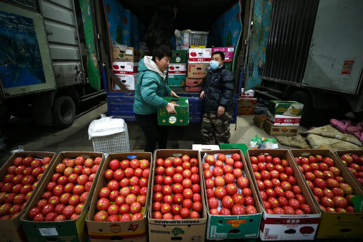 Vendors selling tomatoes wait for customers at a market in Shenyang, Liaoning Province, China, on Dec. 9, 2021. (STR/AFP via Getty Images)