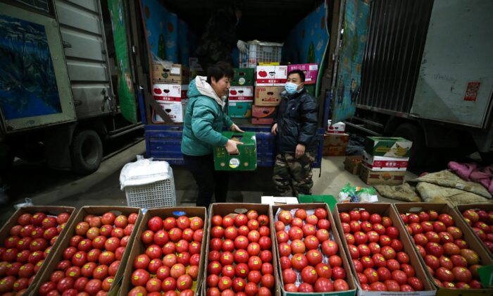 Vendors selling tomatoes wait for customers at a market in Shenyang, Liaoning Province, China, on Dec. 9, 2021. (STR/AFP via Getty Images)