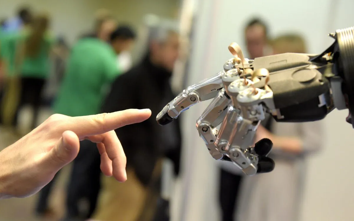 A man moves his finger toward SVH (Servo Electric 5 Finger Gripping Hand) automated hand made by Schunk during the 2014 IEEE-RAS International Conference on Humanoid Robots in Madrid on Nov. 19, 2014. (Gerard Julien/AFP via Getty Images)