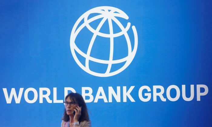 A participant stands near a logo of the World Bank at the International Monetary Fund—World Bank Annual Meeting in Nusa Dua, Bali, Indonesia, on Oct. 12, 2018. (Johannes P. Christo/Reuters)