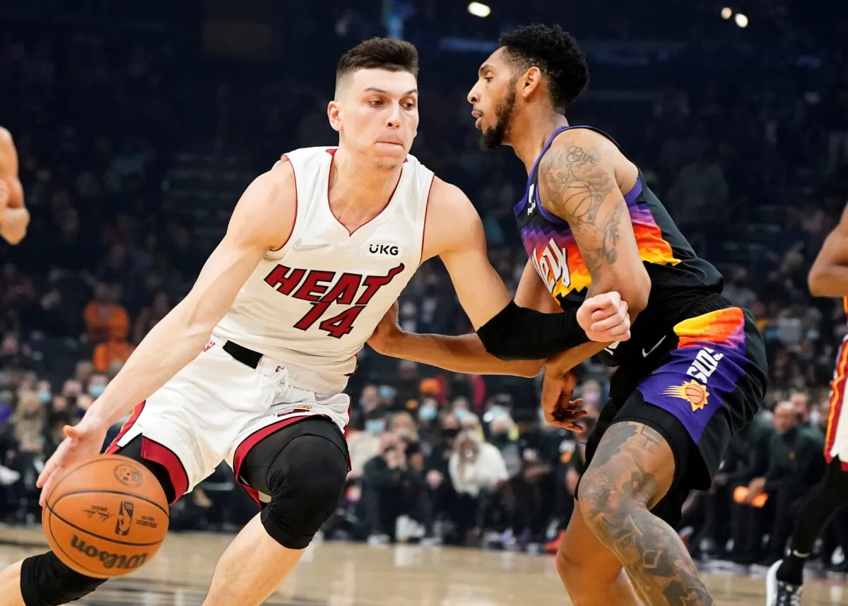 Miami Heat's Tyler Herro (14) drives around Phoenix Suns' Cameron Payne during the first half of an NBA basketball game in Phoenix, on Jan. 8, 2022. (Darryl Webb/AP Photo)