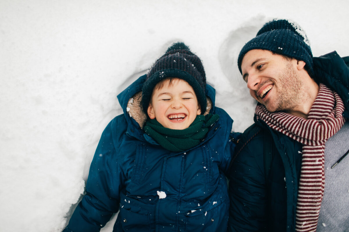 Photo of a boy and his father enjoying winter magic on the snow