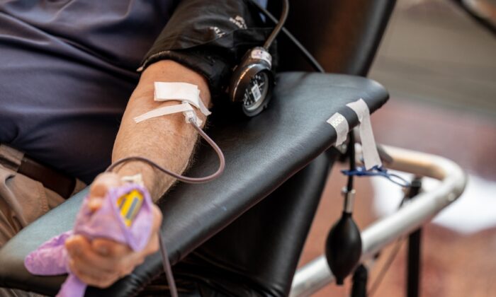 A man gives blood at a blood drive in Louisville, Ky., on July 7, 2021. (Jon Cherry/Getty Images)