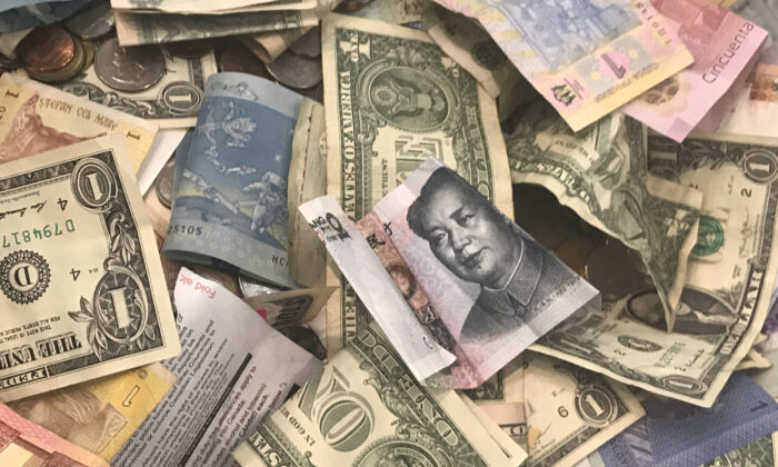 U.S. dollars and other world currencies lie in a charity receptacle at Pearson international airport in Toronto, Ontario, Canada, on June 13, 2018. (Chris Helgren/Reuters)