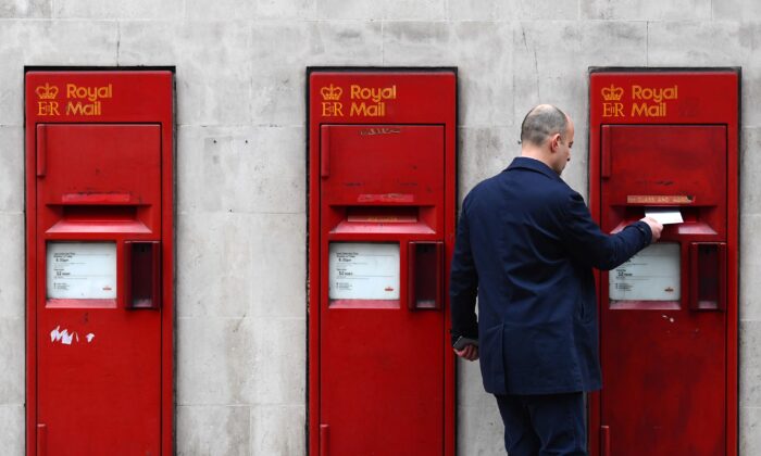 A man posts a letter in a mailbox of a Post Office in London, England on Dec. 19, 2016. (Carl Court/Getty Images)