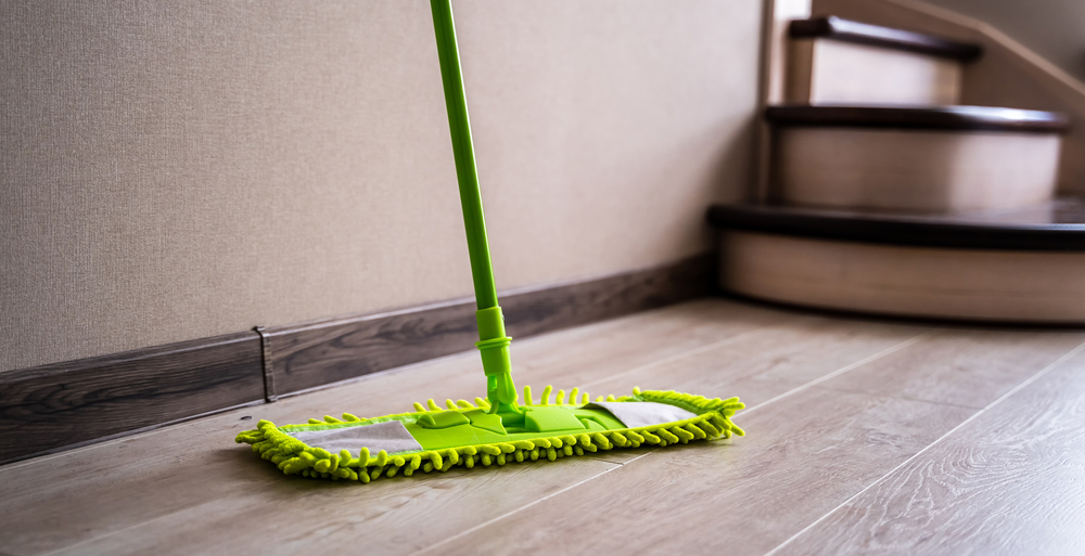 Green,Mop,Standing,Near,White,Wall.,Cleaning,Gear.,Householding.