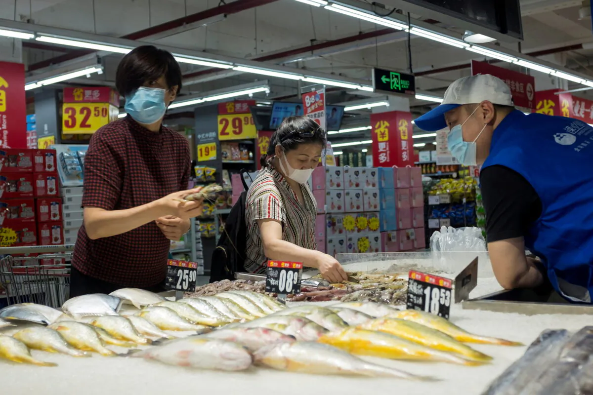 People look at fresh seafood in a supermarket following an outbreak of the coronavirus disease in Beijing on August 13, 2020. (Thomas Peter/Reuters)