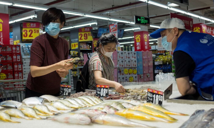 People look at fresh seafood in a supermarket following an outbreak of the coronavirus disease in Beijing on August 13, 2020. (Thomas Peter/Reuters)