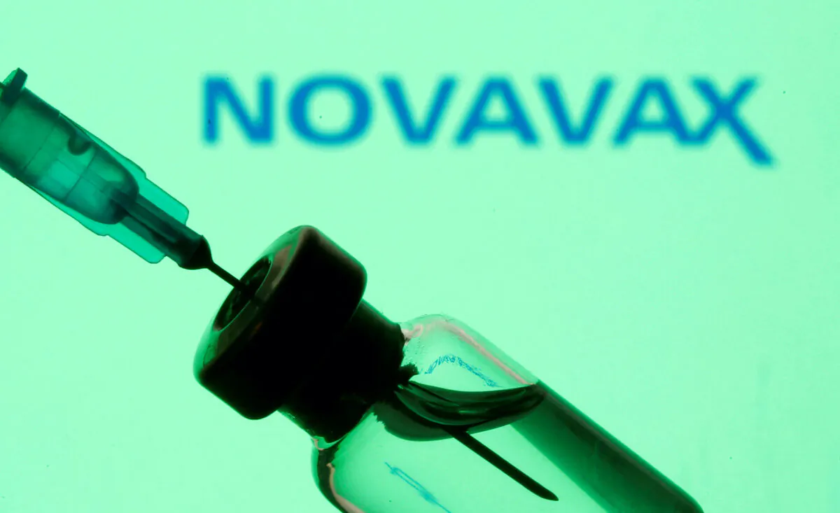 A vial and sryinge are seen in front of a displayed Novavax logo in this illustration taken on Jan. 11, 2021. (Dado Ruvic/Illustration/Reuters)