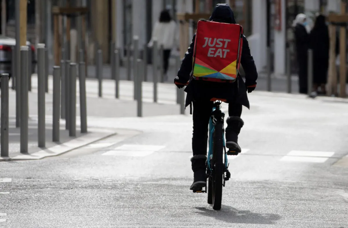 A Just Eat delivery man rides his bicycle in Nice, France on Feb. 16, 2021. (Eric Gaillard/Reuters)