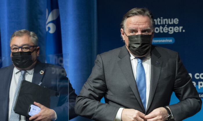 Quebec Premier Francois Legault (R) and then-public health director Horacio Arruda leave a news conference in Montreal on Dec. 30, 2021. (The Canadian Press/Graham Hughes)