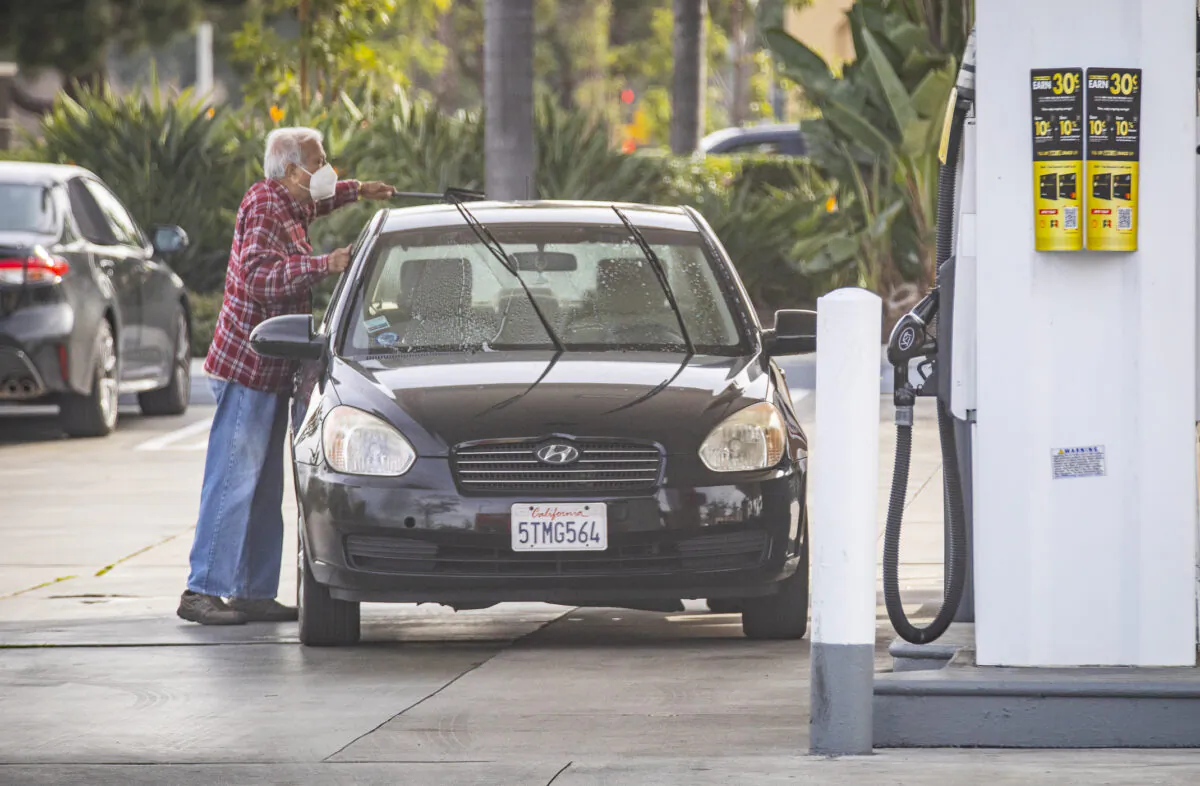 A motorist with his car at a gas station amidst high gas prices in Irvine, Calif., on Jan. 12, 2022. Prices have touched a seven-year-high. (John Fredricks/The Epoch Times)