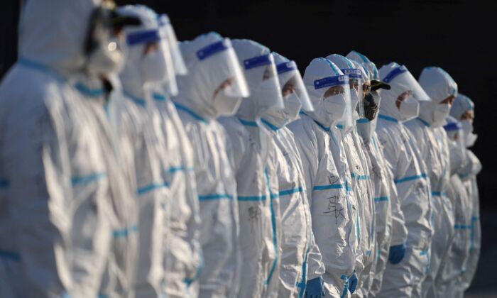 Staff members wearing personal protective equipment prepare to spray disinfectant outside a shopping mall in Xi'an city in north China's Shaanxi Province on Jan. 11, 2022. (STR/AFP via Getty Images)