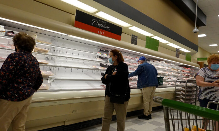 Shelves displaying meat are partially empty as shoppers makes their way through a supermarket in Miami, Fla., on Jan. 11, 2022. (Joe Raedle/Getty Images)