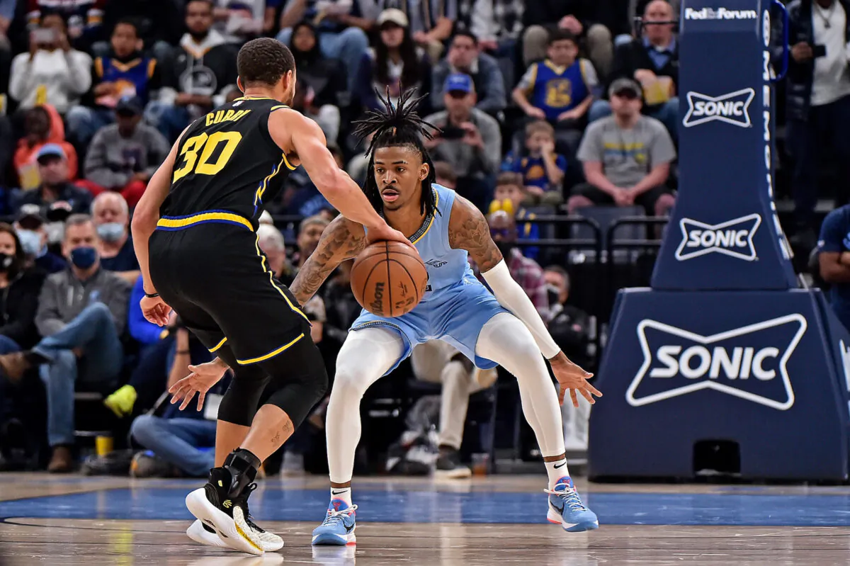 Ja Morant #12 of the Memphis Grizzlies guards Stephen Curry #30 of the Golden State Warriors during the second half at FedExForum in Memphis, on Jan. 11, 2022. (Justin Ford/Getty Images)