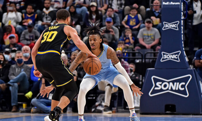 Ja Morant #12 of the Memphis Grizzlies guards Stephen Curry #30 of the Golden State Warriors during the second half at FedExForum in Memphis, on Jan. 11, 2022. (Justin Ford/Getty Images)