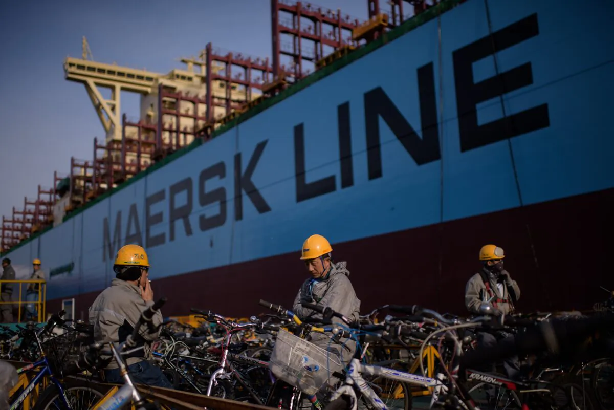 Workers taking a break outside an under-construction Maersk triple-E class container ship at the Daewoo DSME shipyard in Okpo, 60km south of Busan, on Dec. 3, 2014. (Ed Jones/AFP via Getty Images)