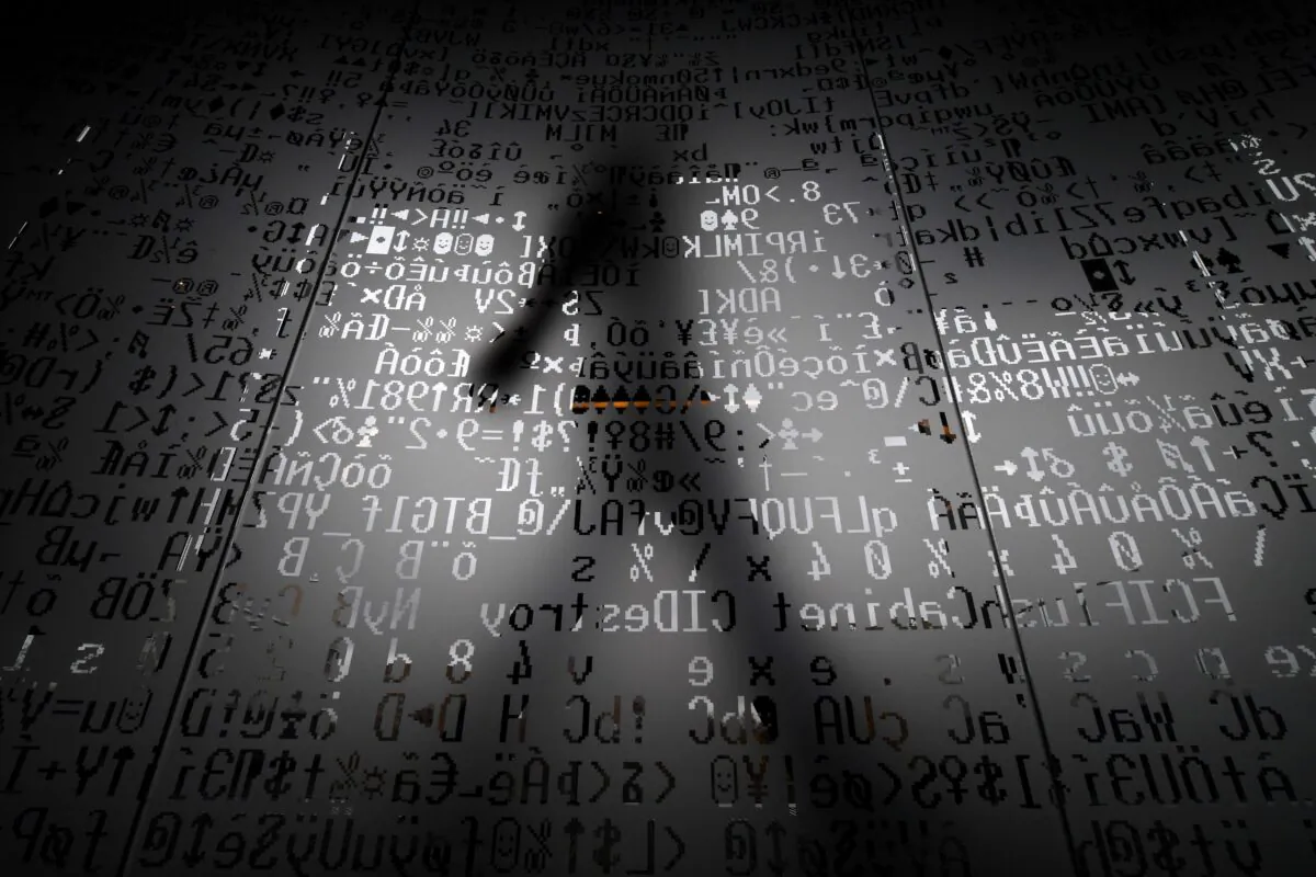An employee walking behind a glass wall with machine coding symbols at the headquarters of Internet security giant Kaspersky in Moscow on Oct. 17, 2016. (Kirill Kudryavtsev/AFP via Getty Images)