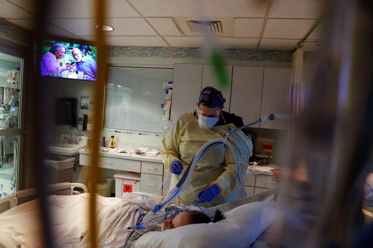 Medical staff treat a COVID-19 patient in their isolation room in the intensive care unit at Western Reserve Hospital in Cuyahoga Falls, Ohio, on Jan. 5, 2022. (Shannon Stapleton/Reuters)
