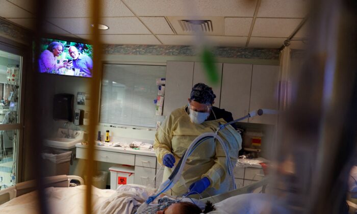 Medical staff treat a COVID-19 patient in their isolation room in the intensive care unit at Western Reserve Hospital in Cuyahoga Falls, Ohio, on Jan. 5, 2022. (Shannon Stapleton/Reuters)