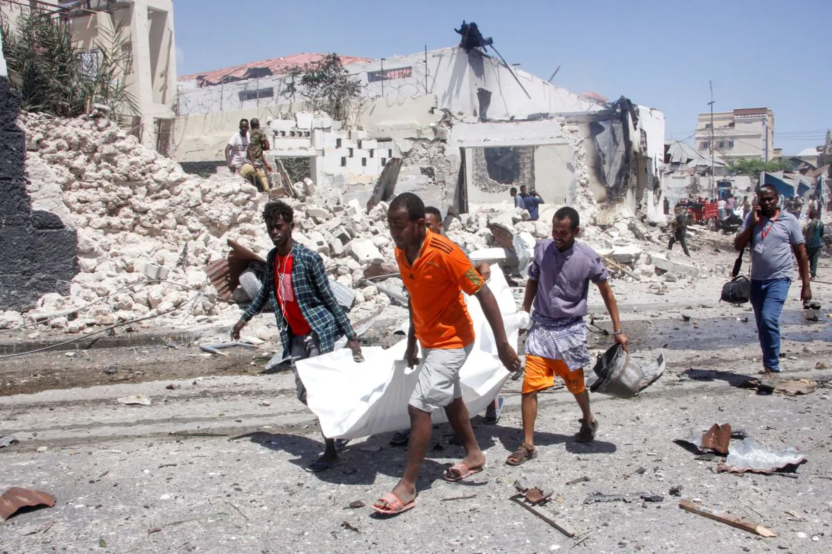 Rescuers carry away the dead body of a civilian who was killed in a blast in Mogadishu, Somalia, on Jan. 12, 2022. (Farah Abdi Warsameh/AP Photo)