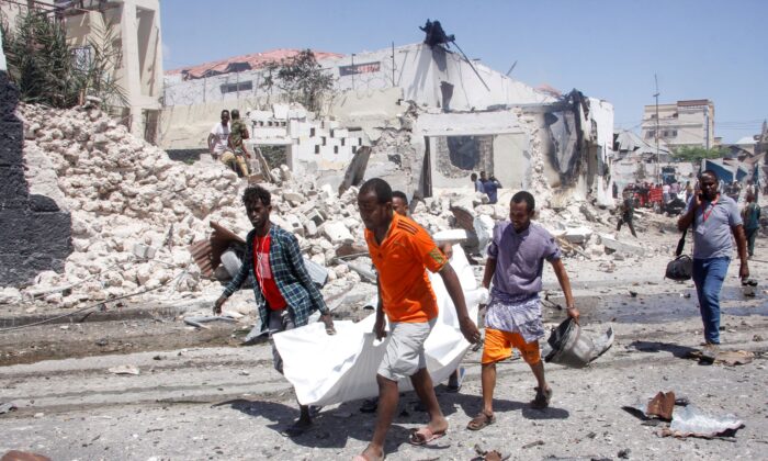 Rescuers carry away the dead body of a civilian who was killed in a blast in Mogadishu, Somalia, on Jan. 12, 2022. (Farah Abdi Warsameh/AP Photo)