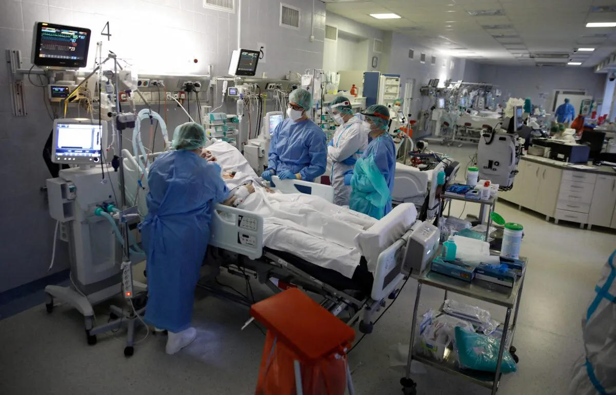 Medical staff members treat patients inside the coronavirus disease (COVID-19) ward at the Central Clinical Hospital of the Ministry of Interior and Administration in Warsaw, Poland, on Jan. 11, 2022. (Kacper Pempel/Reuters)