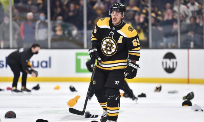 Boston Bruins left wing Brad Marchand (63) skates through a sea of hats, after scoring his third goal of the game during the second period against the Montreal Canadiens at TD Garden, in Boston, on Jan. 12, 2022. (Bob DeChiara/USA TODAY Sports via Field Level Media)