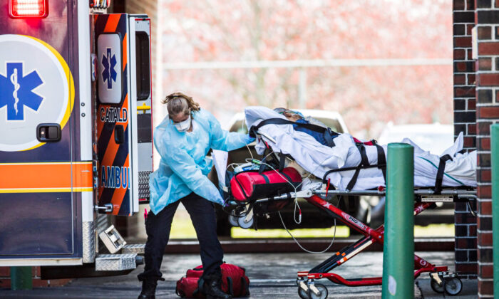 First responders load a patient into an ambulance from a nursing home where multiple people have contracted COVID-19 in Chelsea, Mass., on April 17, 2020. (Scott Eisen/Getty Images)
