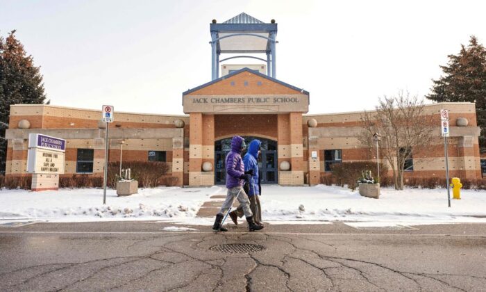 People walk past a school in London, Ont. on Jan. 6, 2022 , the day after the province of Ontario transitioned to online learning in the face of the fast spreading Omicron.  (Geoff Robins/AFP via Getty Images)