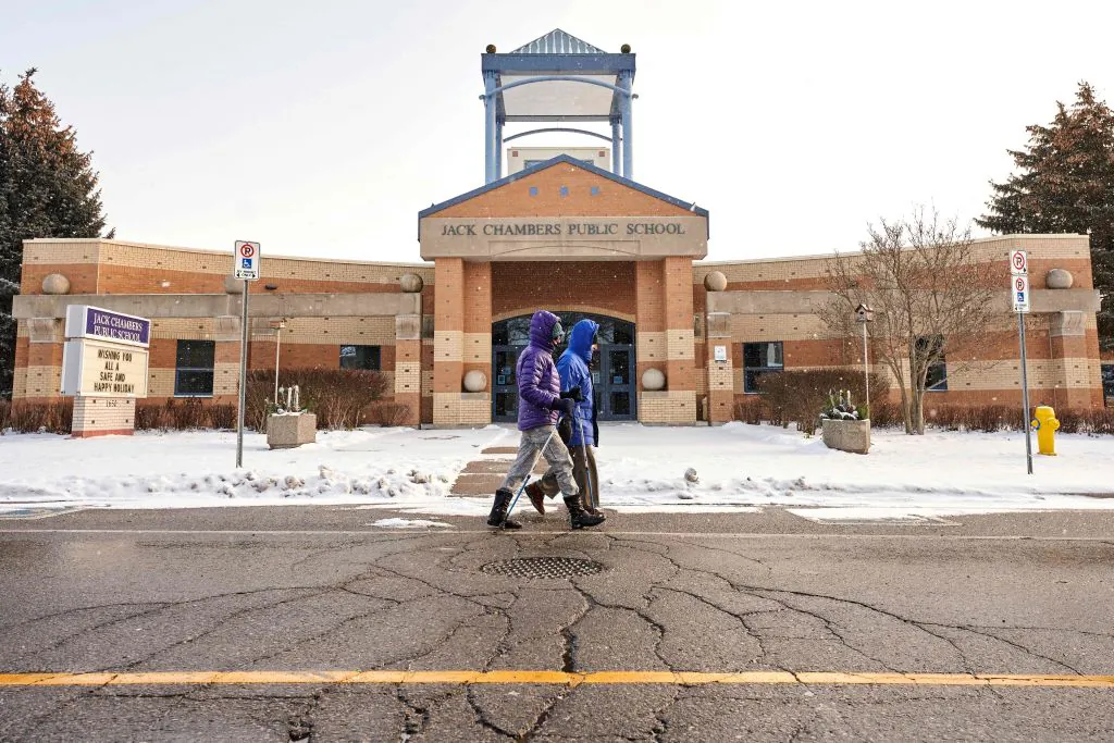 People walk past a school in London, Ont. on Jan. 6, 2022 , the day after the province of Ontario transitioned to online learning in the face of the fast spreading Omicron.  (Geoff Robins/AFP via Getty Images)