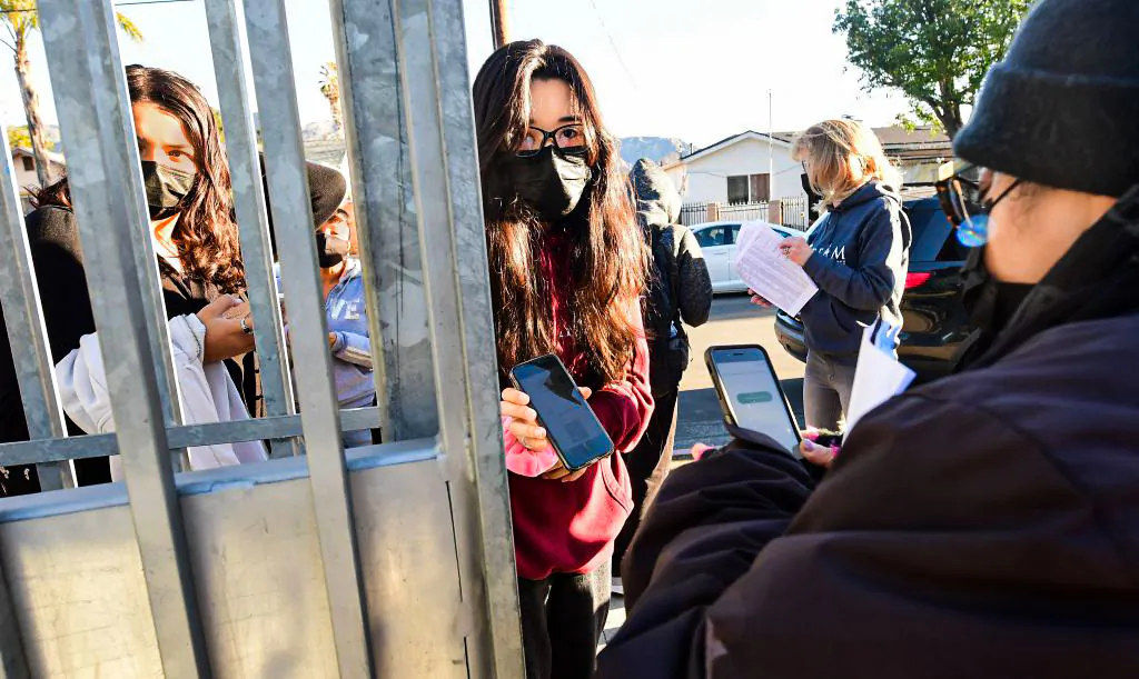 A student shows her negative COVID-19 test result from her cellphone for entry to Olive Vista Middle School on the first day back in Sylmar, Calif., on January 11, 2022. (Frederic J. Brown/AFP via Getty Images)