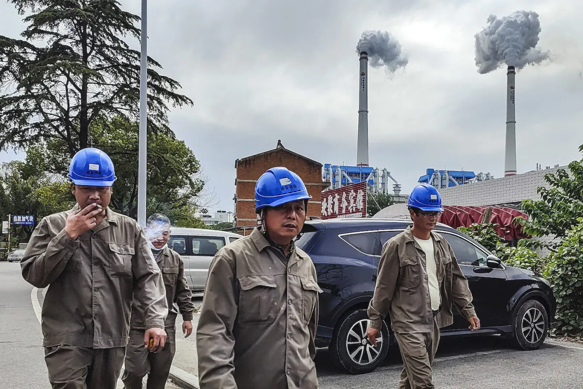 Chinese workers walk past a coal fired power plant in Hanchuan, Hubei Province, on Oct. 13, 2021. (Getty Images)