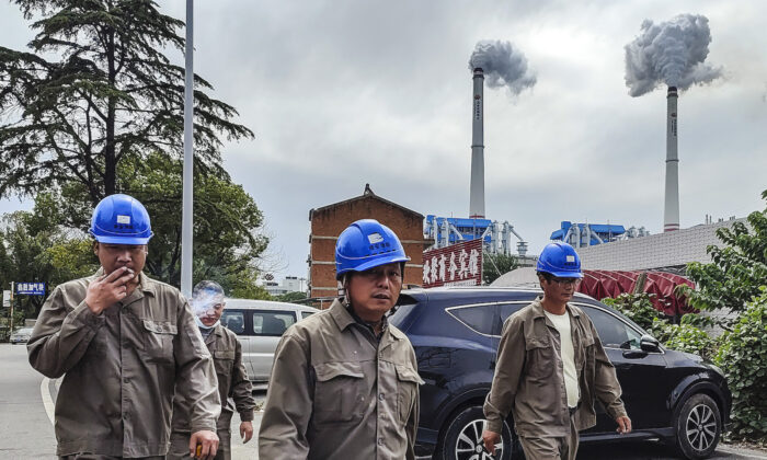 Chinese workers walk past a coal fired power plant in Hanchuan, Hubei Province, on Oct. 13, 2021. (Getty Images)