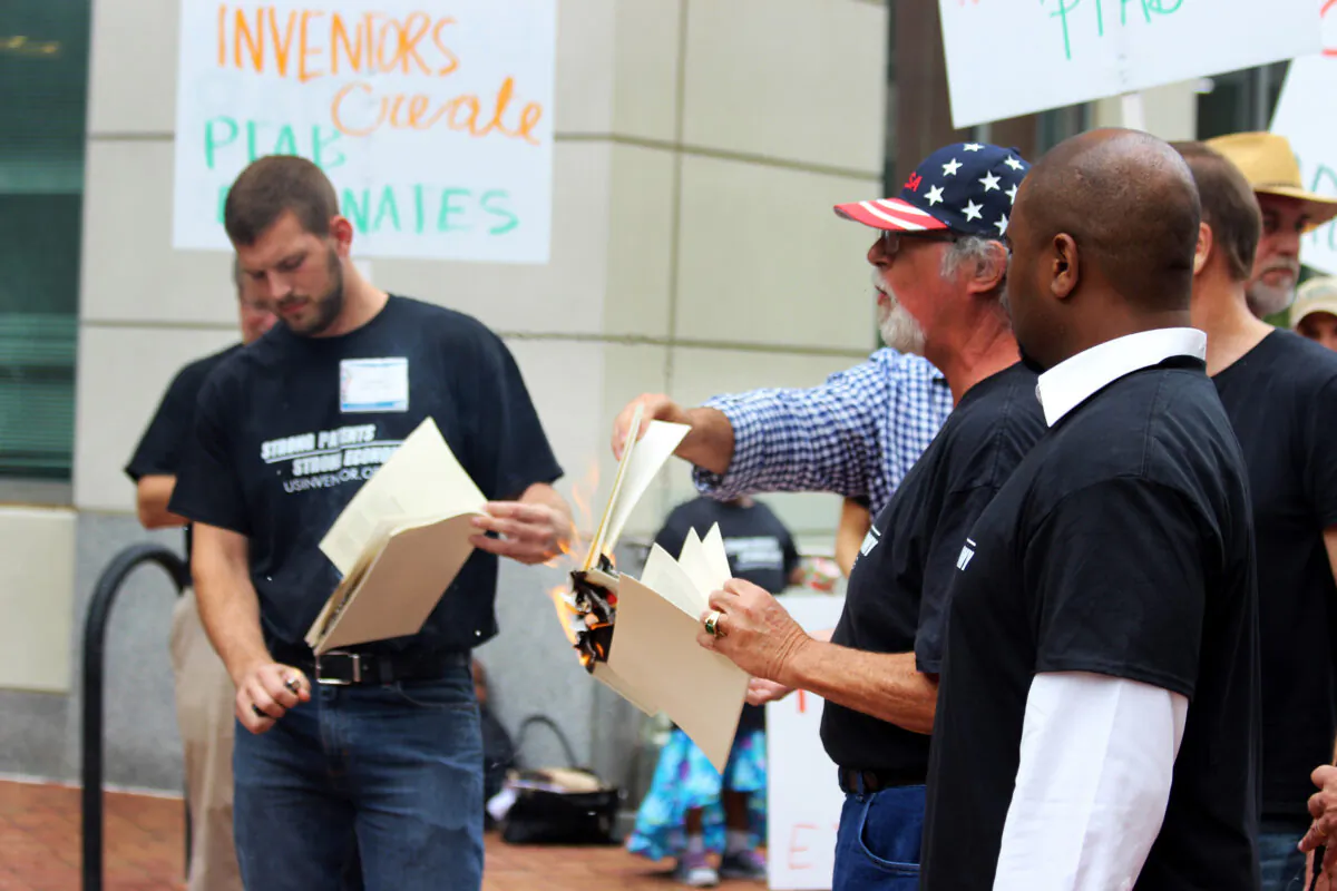 Inventors burn patents in protest outside the Patent Trial and Appeal Board on
Aug. 11, 2017. (Courtesy of US Inventor)
