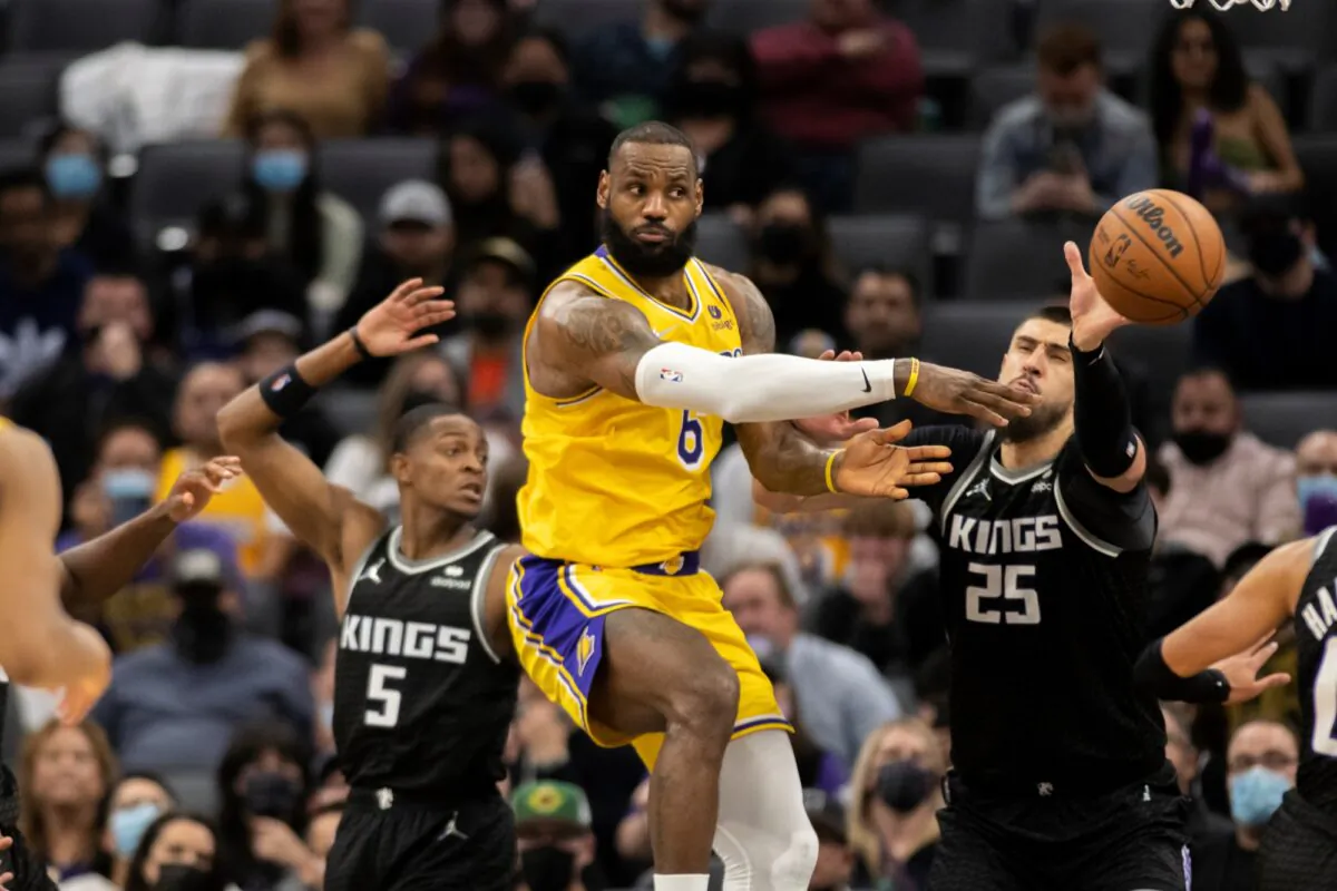 Los Angeles Lakers forward LeBron James (6) passes off while defended by Sacramento Kings guard De'Aaron Fox (5) and center Alex Len (25) in the second half of an NBA basketball game in Sacramento, Calif., on Jan. 12, 2022. (José Luis Villegas/AP Photo)