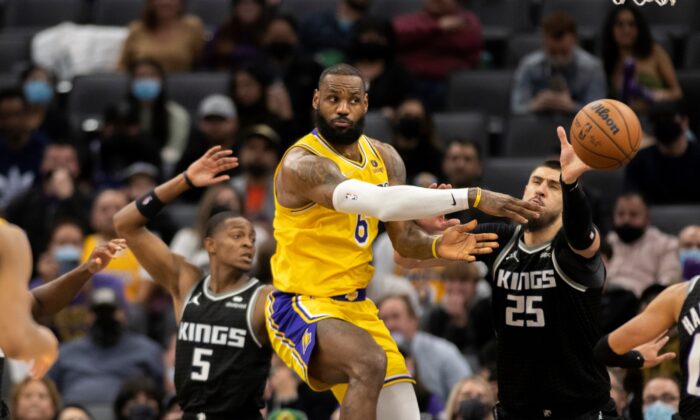 Los Angeles Lakers forward LeBron James (6) passes off while defended by Sacramento Kings guard De'Aaron Fox (5) and center Alex Len (25) in the second half of an NBA basketball game in Sacramento, Calif., on Jan. 12, 2022. (José Luis Villegas/AP Photo)