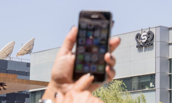 An Israeli woman uses her iPhone in front of the building housing the Israeli NSO group, in Herzliya, near Tel Aviv, Israel, on Aug. 28, 2016. (Jack Guez/AFP via Getty Images)