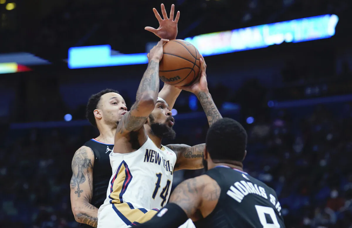 New Orleans Pelicans player Brandon Ingram (14) goes to the basket between Los Angeles Clippers forward Marcus Morris Sr., foreground, and guard Amir Coffey in the first half of an NBA basketball game in New Orleans on Jan. 13, 2022. (AP Photo/Gerald Herbert)