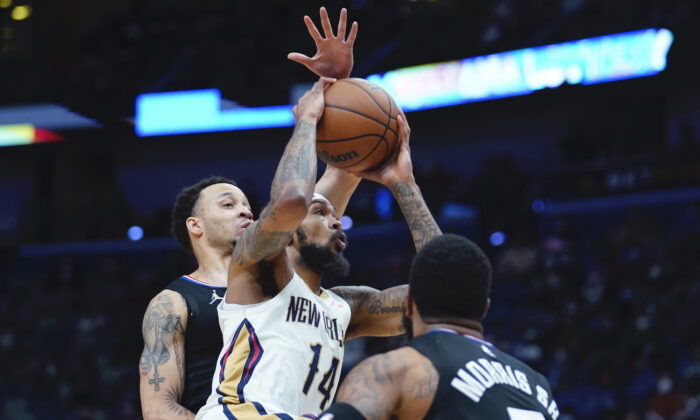 New Orleans Pelicans player Brandon Ingram (14) goes to the basket between Los Angeles Clippers forward Marcus Morris Sr., foreground, and guard Amir Coffey in the first half of an NBA basketball game in New Orleans on Jan. 13, 2022. (AP Photo/Gerald Herbert)