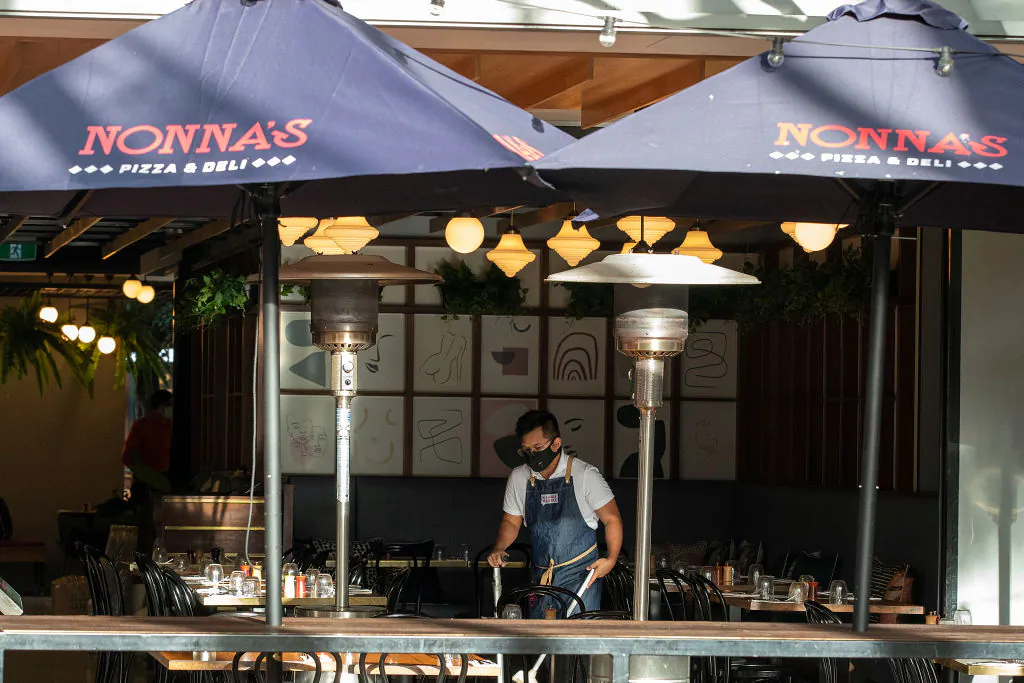 A worker cleans while wearing a mask at a restaurant at Southbank, Brisbane in Australia, on June 29, 2021. (Jono Searle/Getty Images)