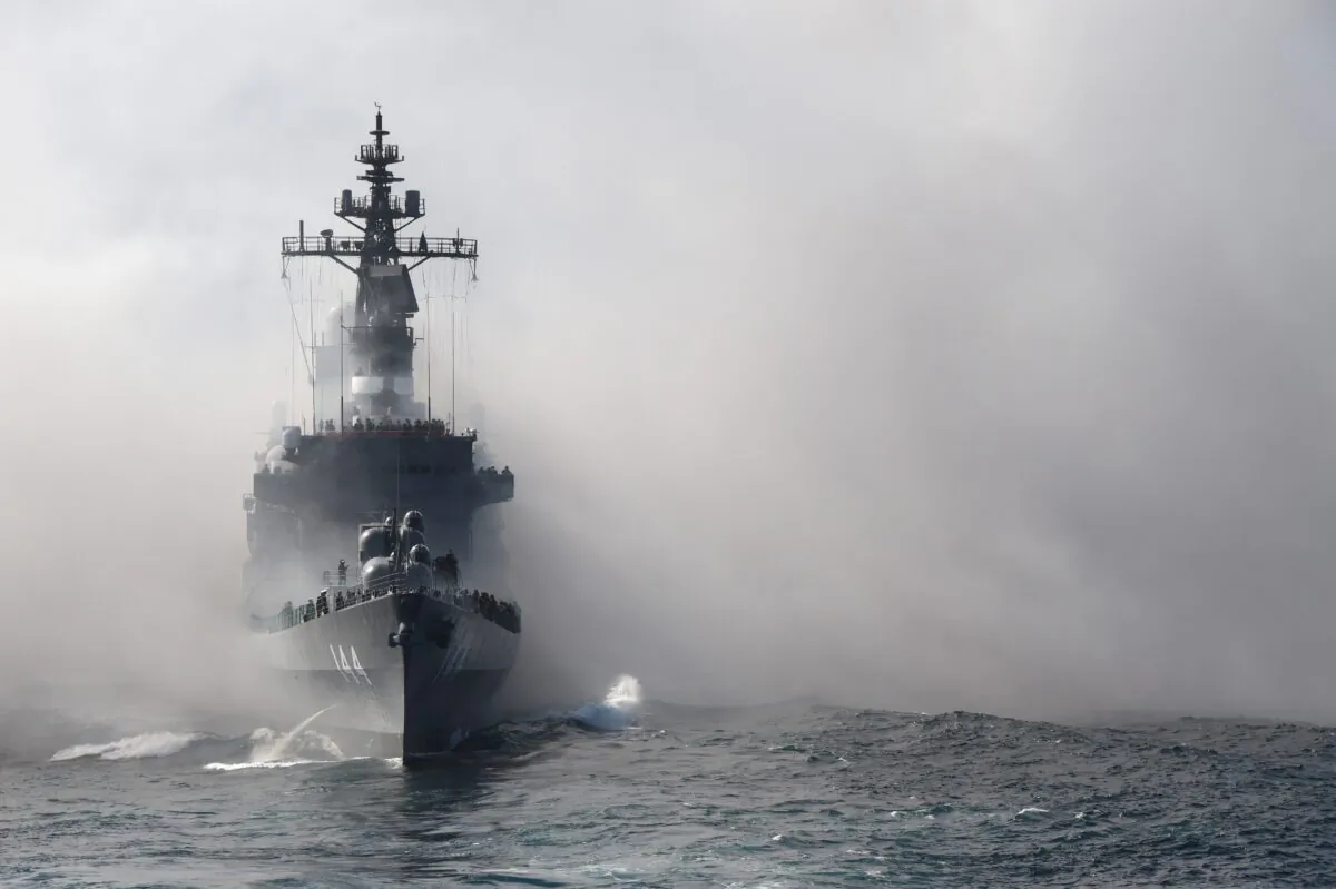 Japan's Maritime Self-Defense Force (MSDF) escort ship Kurama sails through smoke during a fleet review off Sagami Bay, Kanagawa prefecture, on Oct. 18, 2015. Thirty-six MSDF vessels and navy ships from Australia, India, France, South Korea and the United States participated in the fleet review. (Toru Yamanaka/AFP via Getty Images)